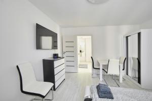 Habitación blanca con mesa y sillas blancas en Apartament Lelewela 8 en Olsztyn