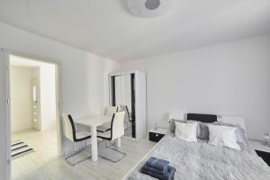 a bedroom with a bed and a desk and a table at Apartament Lelewela 8 in Olsztyn