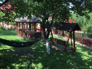a hammock in a tree with a gazebo at Pensiunea Alina in Agapia +24 photos