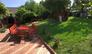 a patio with a table and chairs in a yard at Pensiunea Alina in Agapia