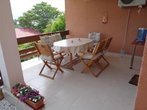 a table and chairs on a patio with a balcony at Apartment Golf in Star Dojran