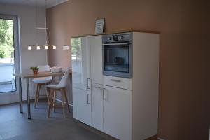 a kitchen with a white refrigerator with a microwave at TOP Ferien Apartment Bohmte in Bohmte