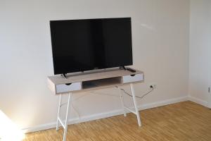 a flat screen tv on a stand in a room at TOP Ferien Apartment Bohmte in Bohmte