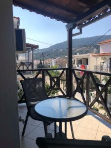 a table and a chair on a balcony with a view at Stavroula's House in Skiathos