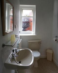 baño con lavabo y aseo y ventana en The Highfield Private Hotel en Blackpool