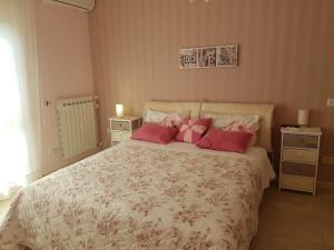 ein Schlafzimmer mit einem großen Bett mit rosa Kissen in der Unterkunft Iris Appartamenti in Santa Maria La Carità