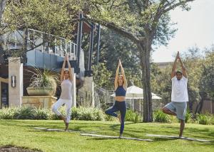 a group of people doing yoga in the grass at Four Seasons Hotel Austin in Austin