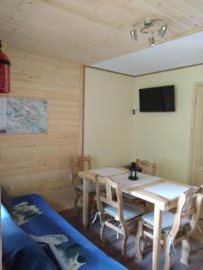 a dining room with a table and chairs and a tv at Domek na Wierchach in Uherce Mineralne (7)