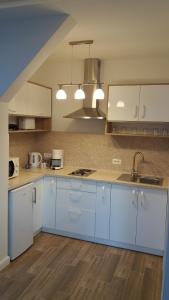 een grote keuken met witte kasten en een wastafel bij Welcome Apartment in Timişoara
