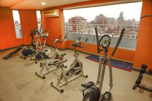 a gym with three exercise bikes in front of a window at Chilean Suites and Apartment in Santiago