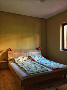 a bedroom with a bed with a colorful blanket on it at Vila SiVa in Ohrid +25 photos