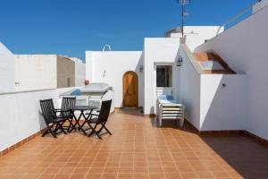 a patio with chairs and a table on a roof at Cactus Ville Playa in Arinaga