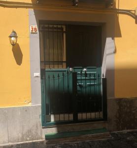 eine grüne Tür an der Seite eines Gebäudes in der Unterkunft Sole House in Neapel
