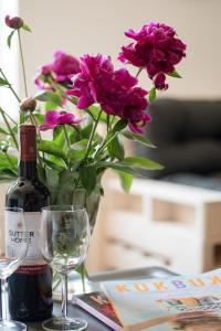 a bottle of wine and a vase with purple flowers at THE HEART OF NOWA HUTA - free garage in Krakow
