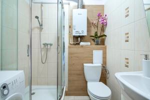 a bathroom with a shower and a toilet and a sink at Sleepy3city Slaska 31 in Gdynia