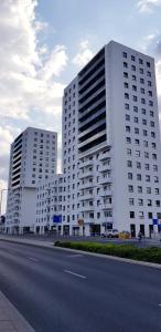two large white buildings on the side of a road at Bułgarska 59A- (1/2) piękny widok 14 piętro in Poznań