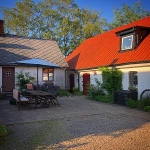 an orange roofed house with a picnic table in the courtyard at Karlsborg Rum och Frukost in Ystad