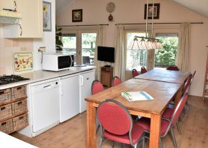 Il comprend une cuisine et une salle à manger avec une table et des chaises en bois. dans l'établissement Country House Erf Bosgunst, à Vorden