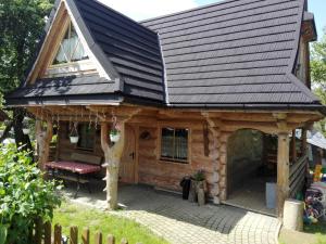 una cabaña de madera con techo de gambrel en Domek Góralski W Ogrodzie, en Małe Ciche