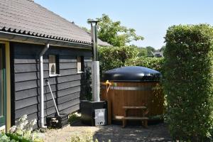 una gran bañera de hidromasaje al aire libre de una casa en Country House Erf Bosgunst, en Vorden