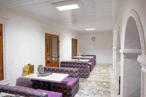 a room with three tables and purple chairs at Conacul Pitusca in Pituşca