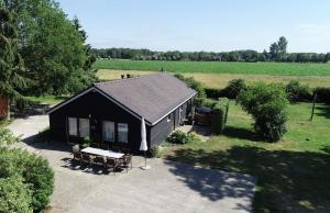 une maison noire avec une table de pique-nique dans une cour dans l'établissement Country House Erf Bosgunst, à Vorden