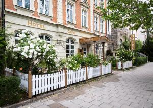 ein Hotel mit einem weißen Zaun vor einem Gebäude in der Unterkunft Hotel Burghof in Hof