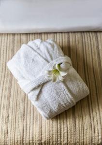 un asciugamano con un fiore sopra un letto di Hotel Burghof a Hof