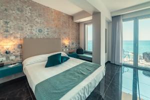 a hotel room with a large bed and a large window at Nautilus Hotel in Giardini Naxos