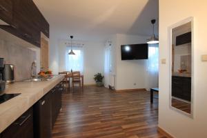 kuchnia z drewnianą podłogą i blatem kuchennym w obiekcie ApartDębki w mieście Odargowo