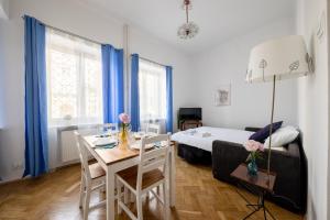 華沙的住宿－WSTApartments CentralOne Górskiego 1，客房设有桌子和一张带蓝色窗帘的床。