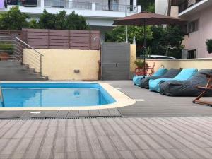 a pool with a couch and chairs in it at Christina Studios & Apartments in Parga