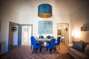 a dining room with a table and blue chairs at Suite Re Riccardo in Caserta