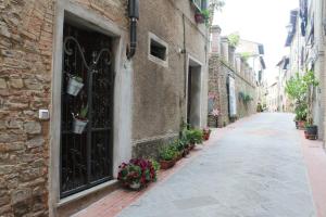 an alley with a door and flowers in pots at La Casina di Via Cresci, 14 in Montaione