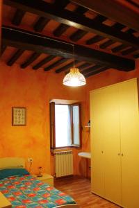 a bedroom with orange walls and a bed and a window at La Casina di Via Cresci, 14 in Montaione
