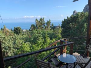 a balcony with two chairs and the ocean in the background at Guest House Lesnaya Koshka in Simeiz