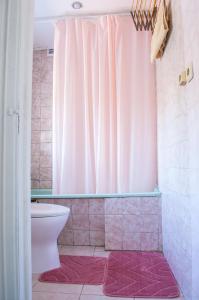 a bathroom with a toilet and a pink shower curtain at квартира в центре in Odesa