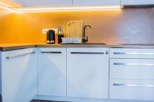 a kitchen with white cabinets and a sink at OLEK in Turawa