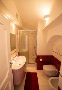 Un baño con lavabo, inodoro y ducha. en Villa Marilisa, en Conca dei Marini