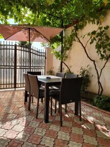 a table with chairs and an umbrella on a patio at Casa Eduard in Eforie Sud