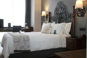 a bedroom with a large white bed with a black headboard at Zócalo Central in Mexico City