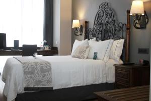 a bedroom with a large white bed with a black headboard at Zocalo Central & Rooftop Mexico City in Mexico City