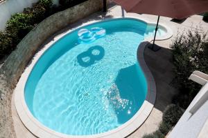una vista aérea de una piscina con sombrilla en Apartments Sakal, en Trogir