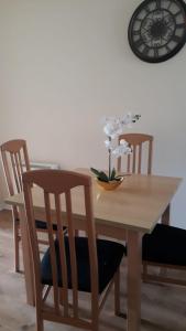 a wooden table with two chairs and a vase with flowers on it at Glen Abhainn Standard Budget Accommodation in Athlone