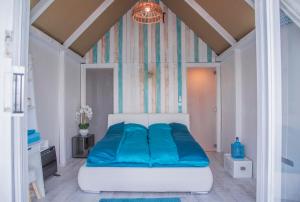 a bedroom with a large bed with blue sheets at LupaGlamping in Budakalász