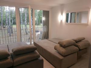 a living room with a bed and a balcony at SANSET APART Okuninka in Okuninka