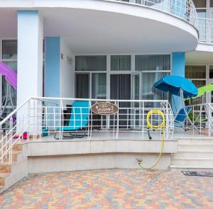 einen Balkon eines Gebäudes mit Stühlen und einem Sonnenschirm in der Unterkunft Apartament First Line in Karolino-Buhas