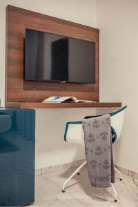 a tv sitting on top of a wooden table at Nautilus Hotel in Giardini Naxos