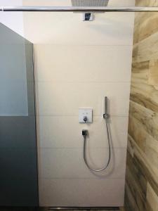 a shower in a bathroom with a hose on a wall at Apartment BENI in Novi Vinodolski
