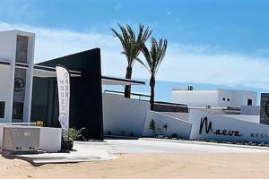 un edificio con un cartel frente a él con palmeras en Casita de Moana, en Puerto Peñasco